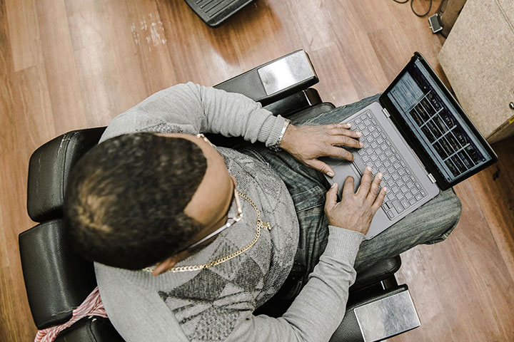 A man sitting on the floor using his laptop.